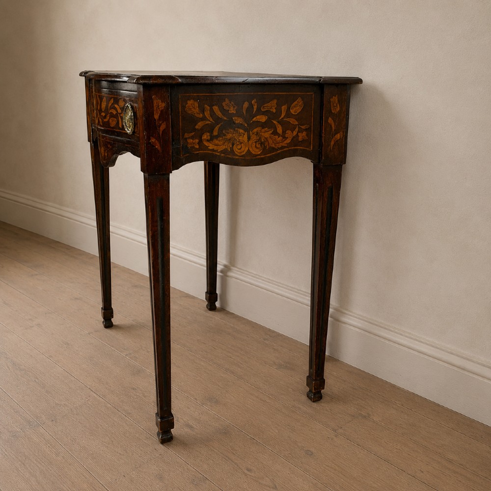 An 18th-century Dutch walnut side table featuring a serpentine front, floral marquetry inlay, a single drawer, and four square tapered legs. View V