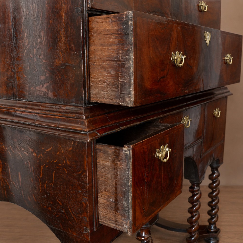 A George I period figured walnut chest on stand featuring engraved brass escutcheons and six barley-twist legs. View IX