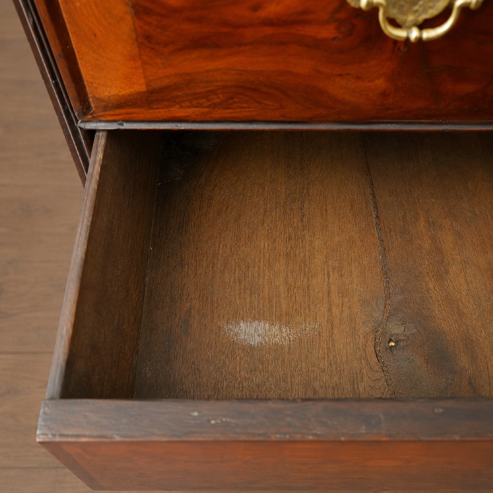 A George I period figured walnut chest on stand featuring engraved brass escutcheons and six barley-twist legs. View X