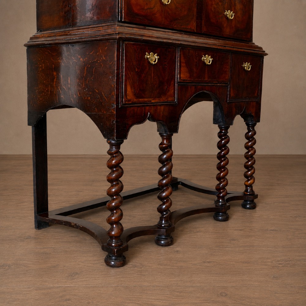 A George I period figured walnut chest on stand featuring engraved brass escutcheons and six barley-twist legs. View XI