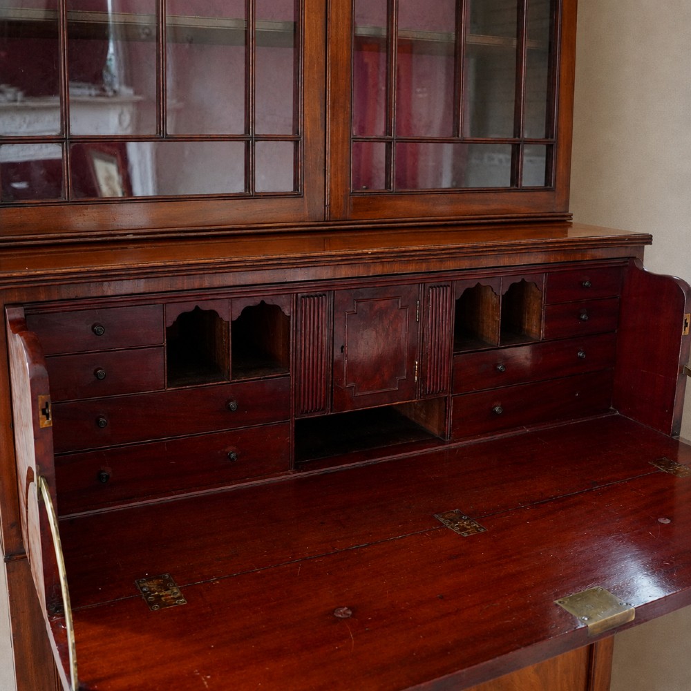 A nineteenth-century George IV mahogany secretaire bookcase with glazed upper doors featuring gothic tracery and a drop-down desk drawer revealing a fitted interior. View IX