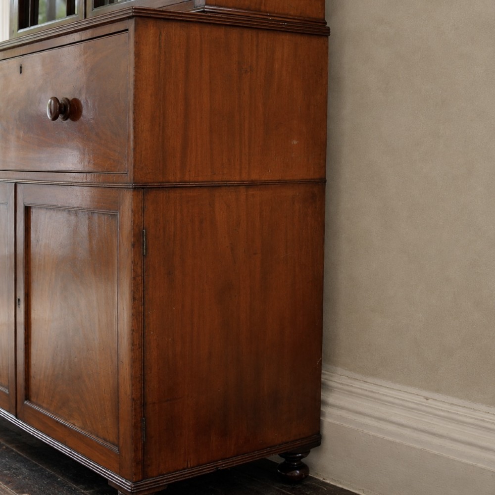 A nineteenth-century George IV mahogany secretaire bookcase with glazed upper doors featuring gothic tracery and a drop-down desk drawer revealing a fitted interior. View XI