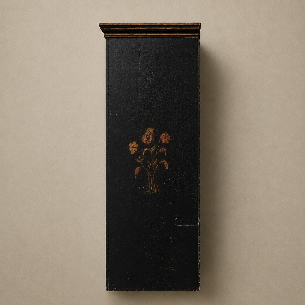 An ebonised black wooden wall cabinet featuring an arched door panel decorated with a hand-painted exotic bird amongst green foliage. View V