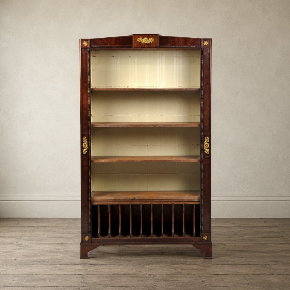 A nineteenth-century French Empire style rosewood open bookcase featuring brass mounts and adjustable shelves above vertical dividers.