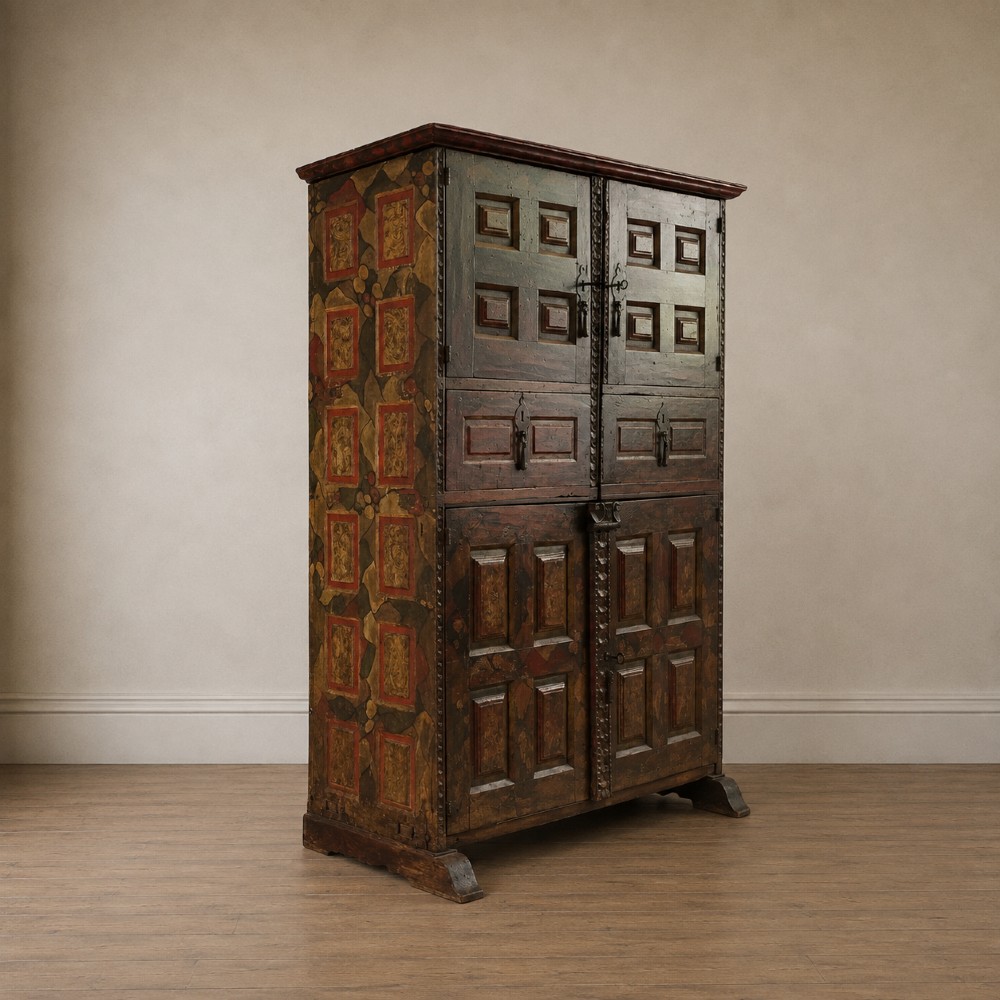 A tall seventeenth-century Spanish oak press cupboard featuring double upper and lower doors decorated with geometric raised panels and painted polychrome geometric patterns. View III