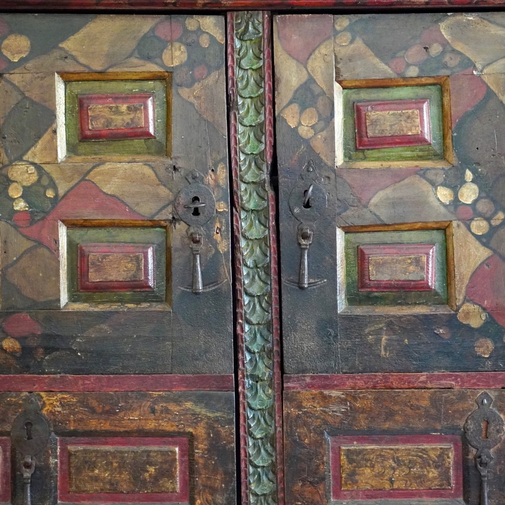 A tall seventeenth-century Spanish oak press cupboard featuring double upper and lower doors decorated with geometric raised panels and painted polychrome geometric patterns. View VIII