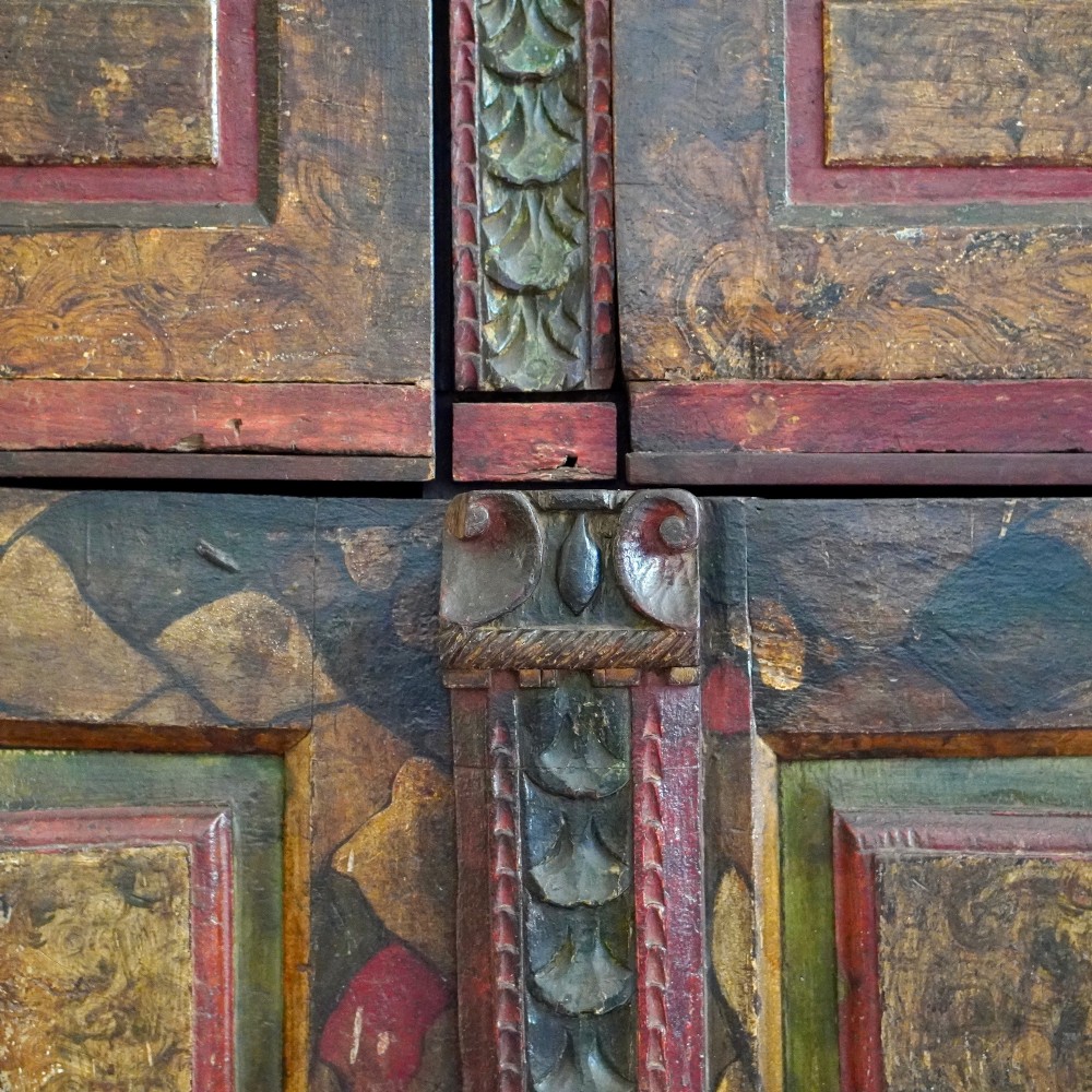 A tall seventeenth-century Spanish oak press cupboard featuring double upper and lower doors decorated with geometric raised panels and painted polychrome geometric patterns. View IX