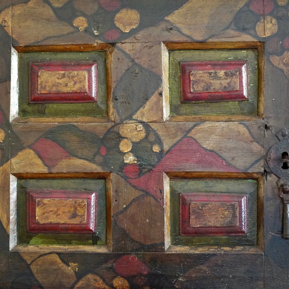 A tall seventeenth-century Spanish oak press cupboard featuring double upper and lower doors decorated with geometric raised panels and painted polychrome geometric patterns. View XII