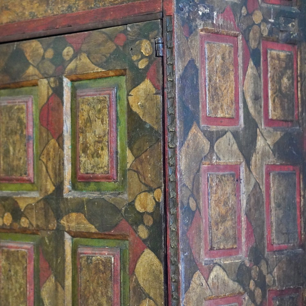 A tall seventeenth-century Spanish oak press cupboard featuring double upper and lower doors decorated with geometric raised panels and painted polychrome geometric patterns. View XIII