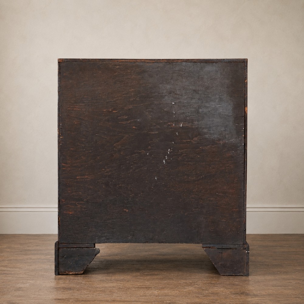 An Early Georgian walnut bureau featuring a sloping drop-front writing lid, four graduated drawers with brass drop handles, and bracket feet. View V