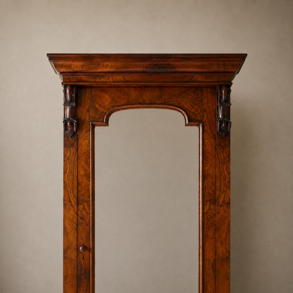 A Victorian single-door wardrobe crafted from figured walnut wood, featuring a central arch-topped mirror panel, carved corbels, and a heavy moulded cornice. View VIII