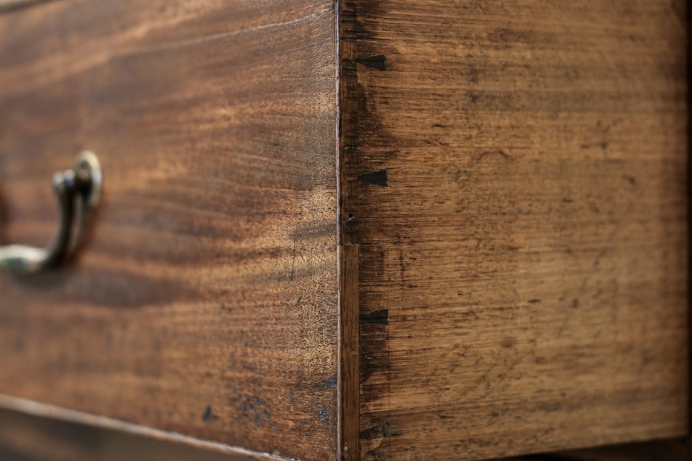 A large George III mahogany breakfront linen press wardrobe featuring central panelled doors above drawers, flanked by side cupboards on bracket feet. View XIV