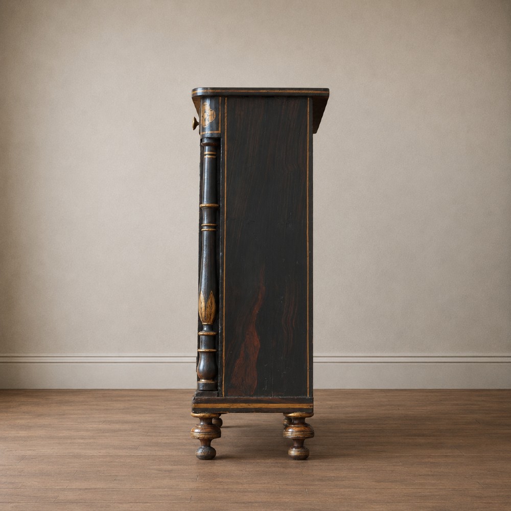 A Regency period side cabinet featuring simulated rosewood graining, gilt corner decorations, turned flanking columns, a top drawer, and two cupboard doors. View VI