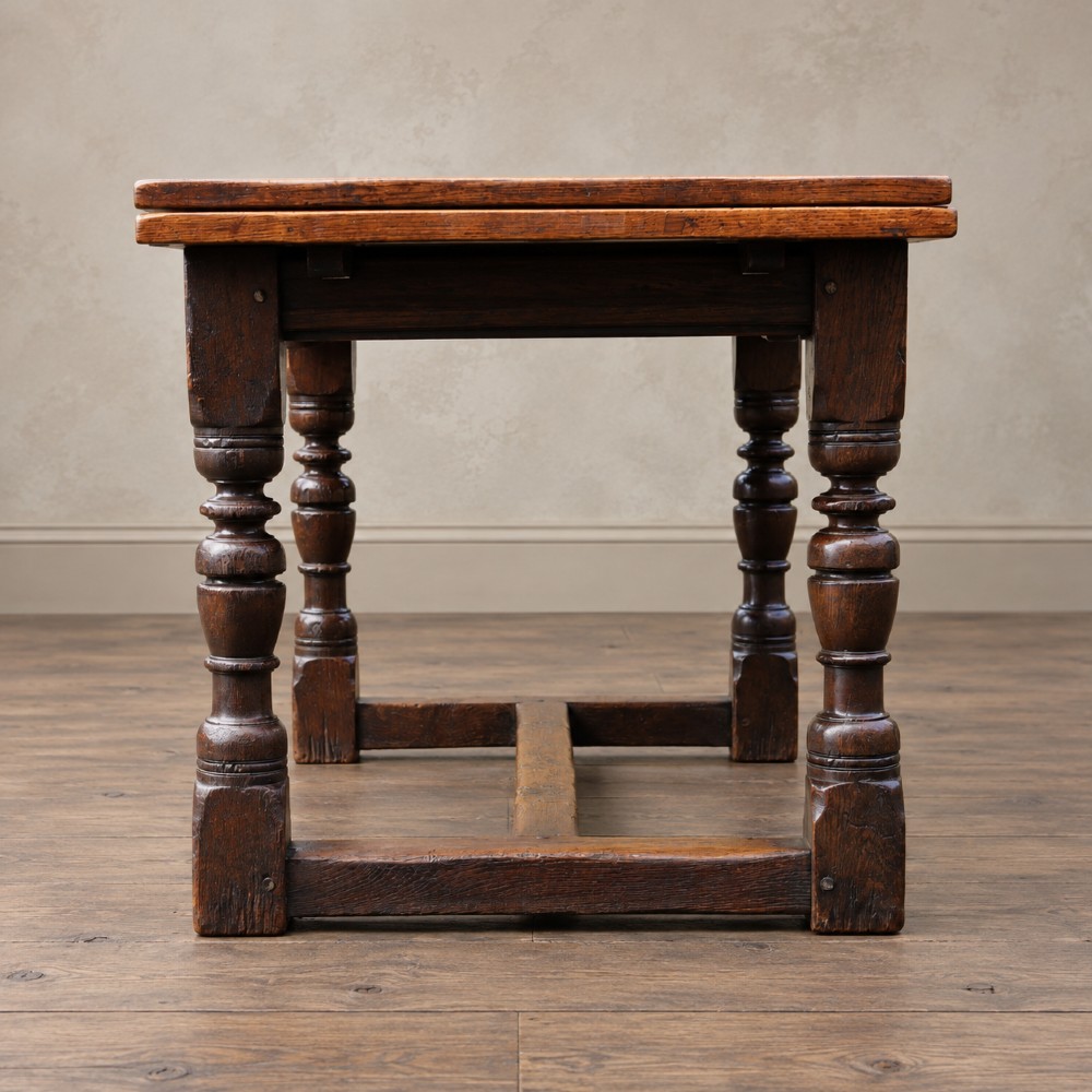 A 17th-century solid oak extending dining table featuring turned legs, lower stretcher rails, and two draw-out end leaves. View VIII