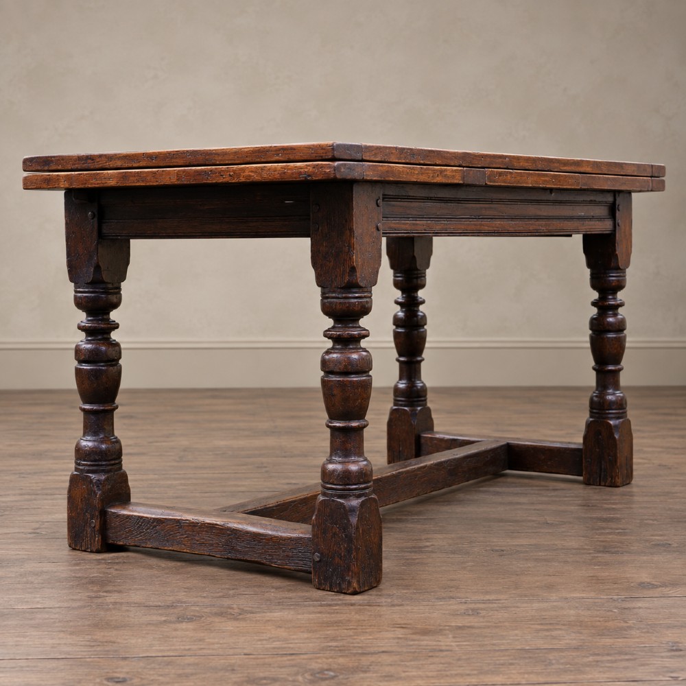 A 17th-century solid oak extending dining table featuring turned legs, lower stretcher rails, and two draw-out end leaves. View XII