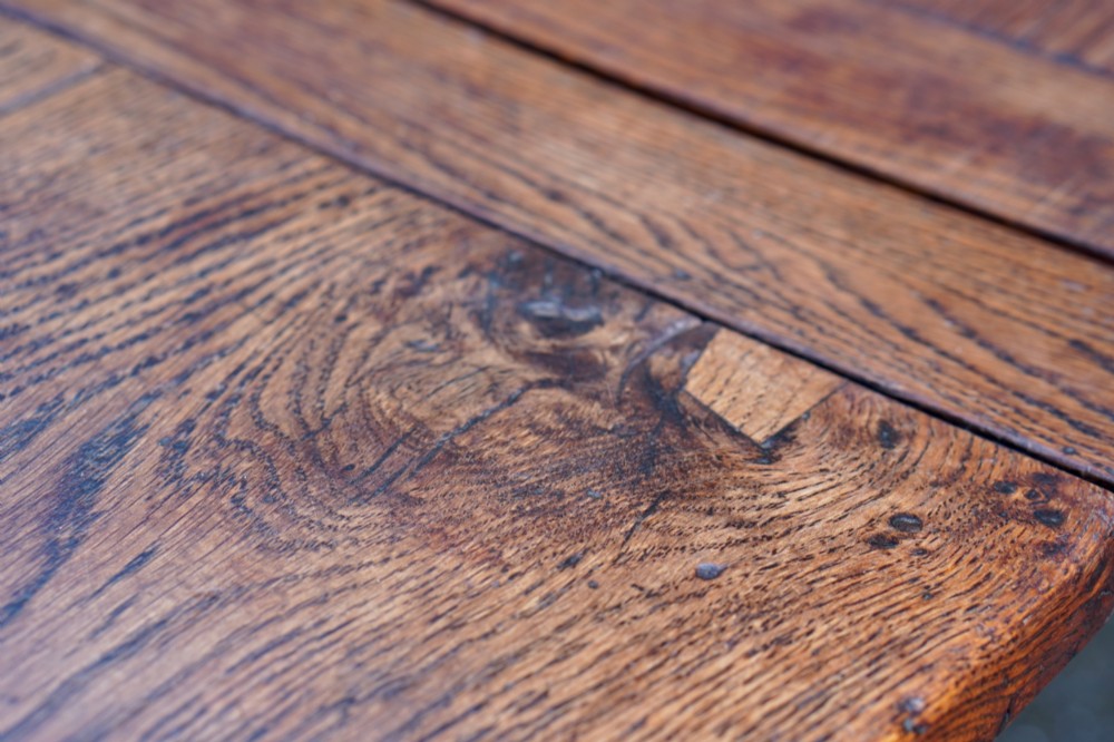 A 17th-century solid oak extending dining table featuring turned legs, lower stretcher rails, and two draw-out end leaves. View XIII