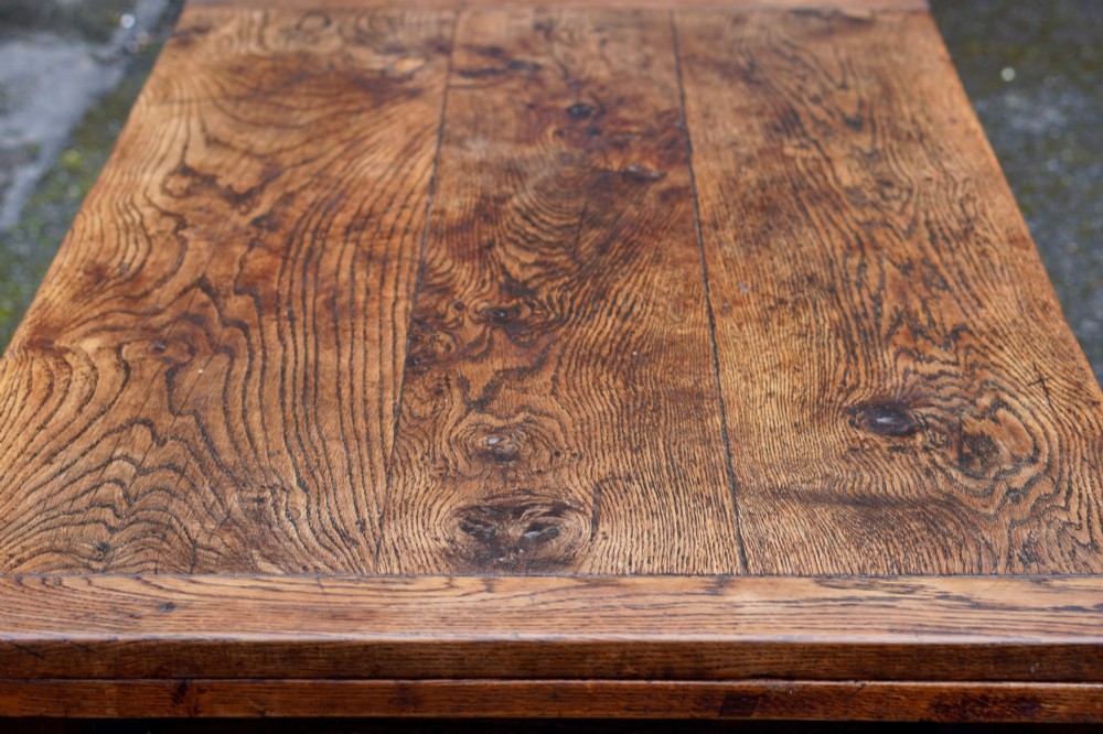 A 17th-century solid oak extending dining table featuring turned legs, lower stretcher rails, and two draw-out end leaves. View XV