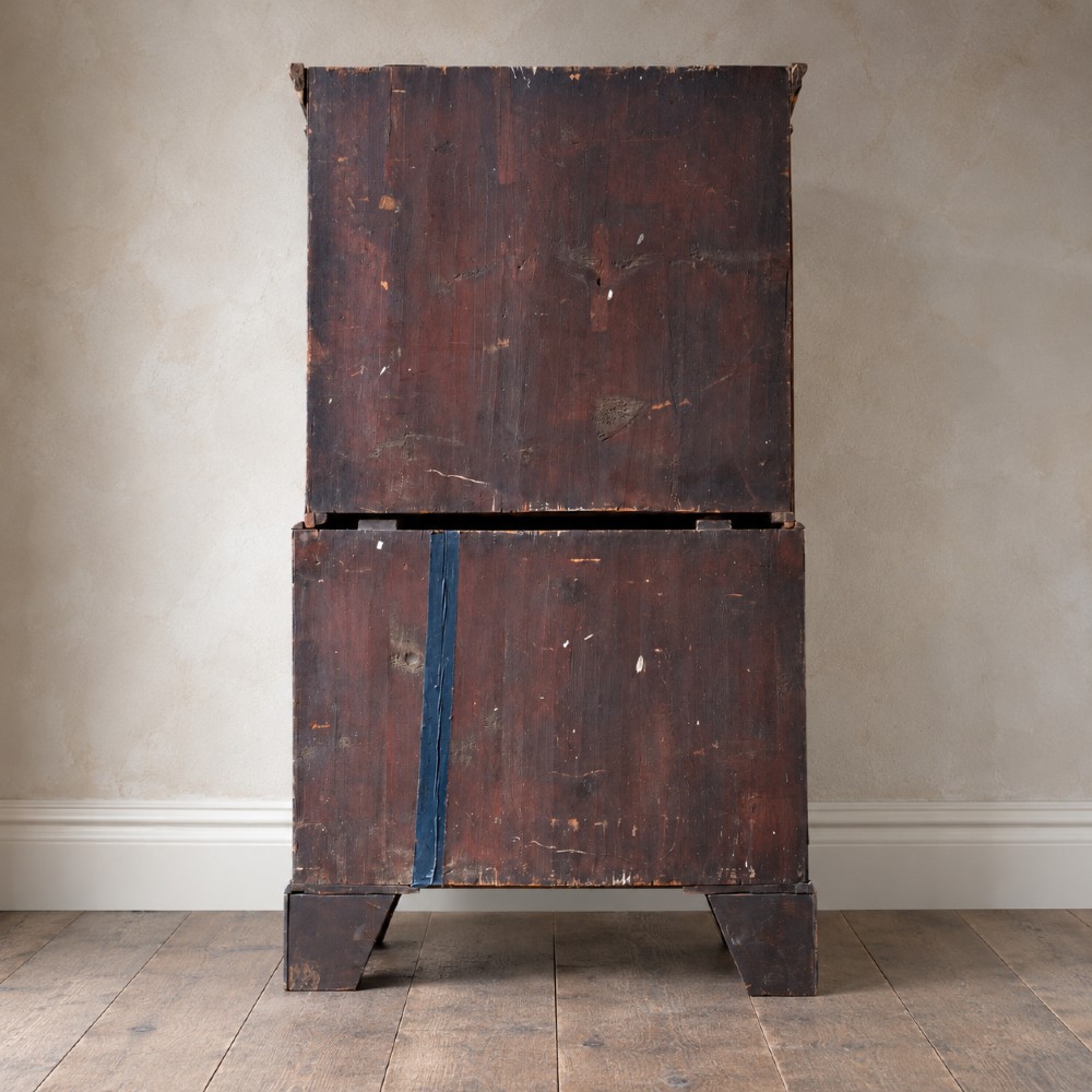An eighteenth-century Georgian figured mahogany chest on chest featuring a carved dentil cornice, brass swan-neck handles, a pull-out brushing slide, and bracket feet. View IV
