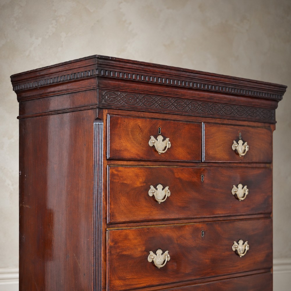 An eighteenth-century Georgian figured mahogany chest on chest featuring a carved dentil cornice, brass swan-neck handles, a pull-out brushing slide, and bracket feet. View VII