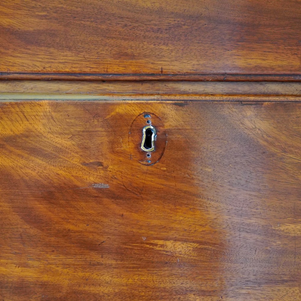 An eighteenth-century Georgian figured mahogany chest on chest featuring a carved dentil cornice, brass swan-neck handles, a pull-out brushing slide, and bracket feet. View XI