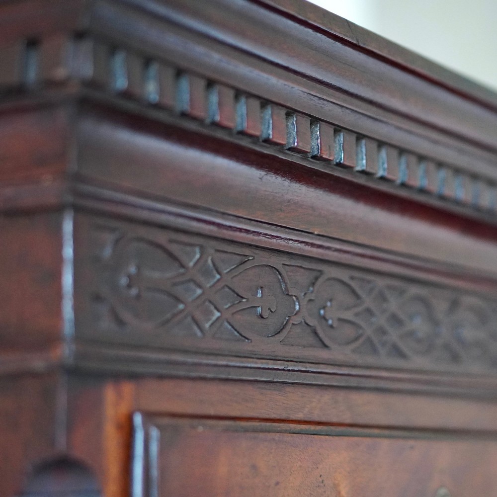 An eighteenth-century Georgian figured mahogany chest on chest featuring a carved dentil cornice, brass swan-neck handles, a pull-out brushing slide, and bracket feet. View XIV