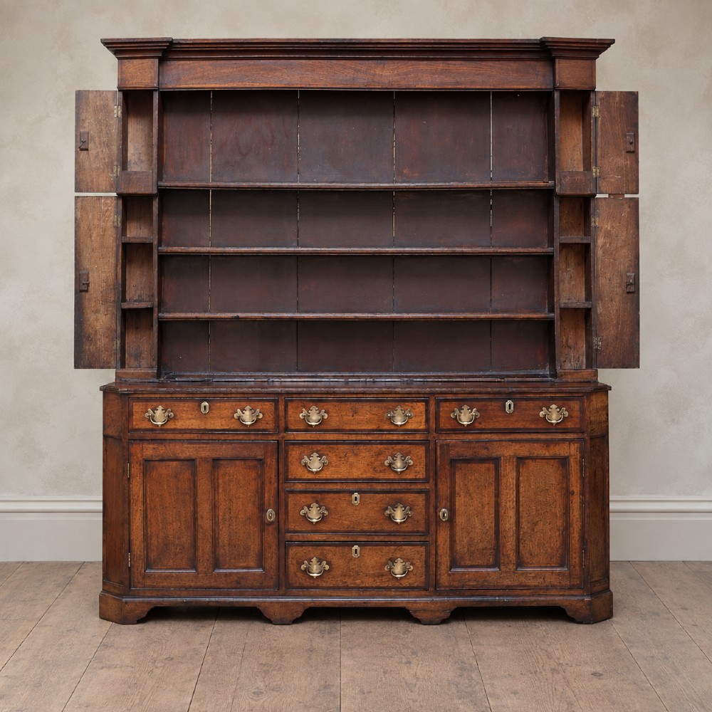 A George II dark oak dresser with a tall open plate rack above a sideboard featuring multiple drawers and twin cupboard doors. View VIII