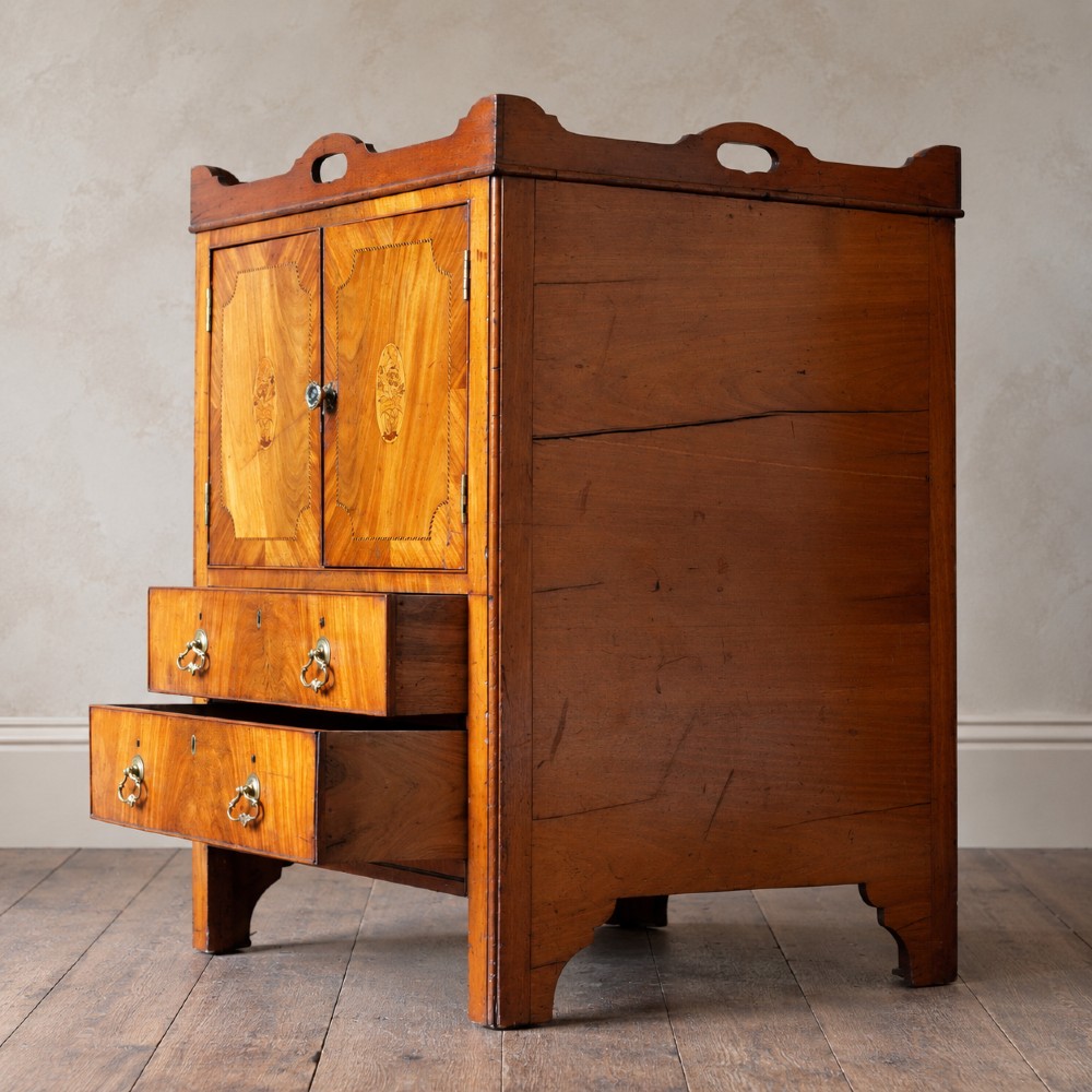 A 19th-century mahogany tray top night commode featuring two cabinet doors with oval marquetry inlays above two drawers with brass handles. View III