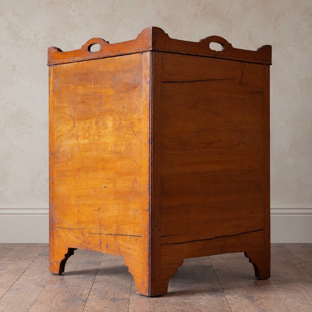A 19th-century mahogany tray top night commode featuring two cabinet doors with oval marquetry inlays above two drawers with brass handles. View VI