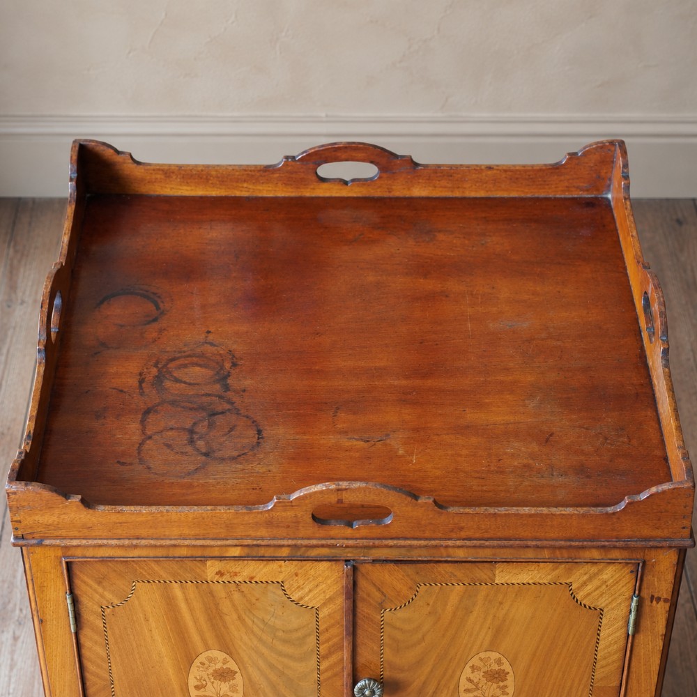 A 19th-century mahogany tray top night commode featuring two cabinet doors with oval marquetry inlays above two drawers with brass handles. View VII