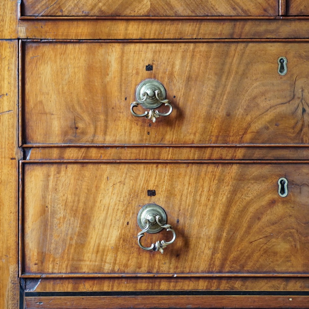 A 19th-century mahogany tray top night commode featuring two cabinet doors with oval marquetry inlays above two drawers with brass handles. View XII