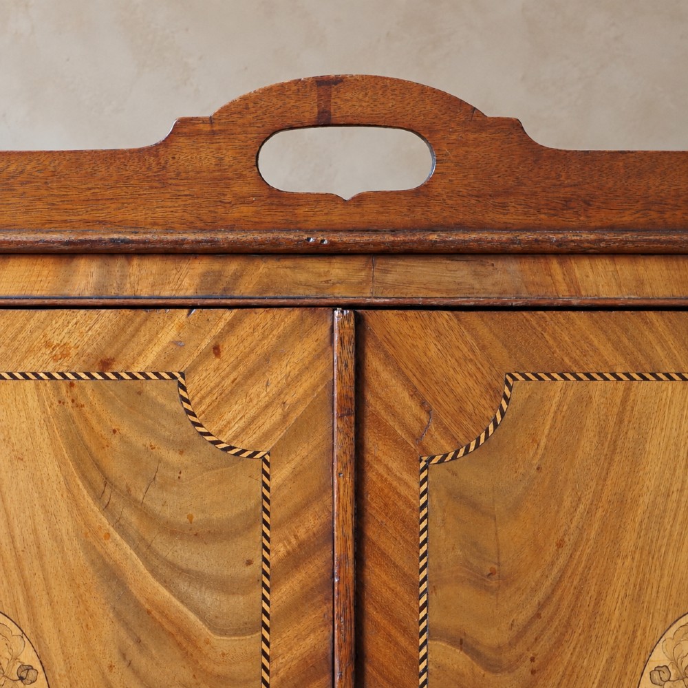 A 19th-century mahogany tray top night commode featuring two cabinet doors with oval marquetry inlays above two drawers with brass handles. View XV