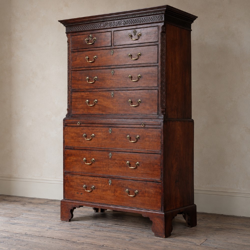 A George III mahogany chest on chest featuring two short over six long graduated drawers, a brushing slide, blind fretwork frieze, brass swan-neck handles, and bracket feet. View III