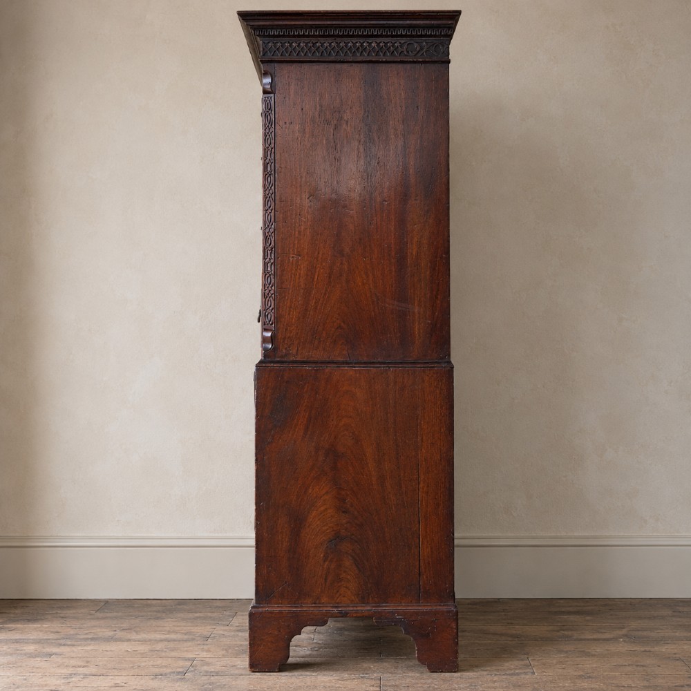 A George III mahogany chest on chest featuring two short over six long graduated drawers, a brushing slide, blind fretwork frieze, brass swan-neck handles, and bracket feet. View IV