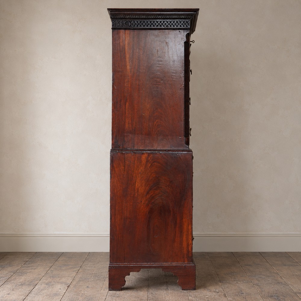 A George III mahogany chest on chest featuring two short over six long graduated drawers, a brushing slide, blind fretwork frieze, brass swan-neck handles, and bracket feet. View VII