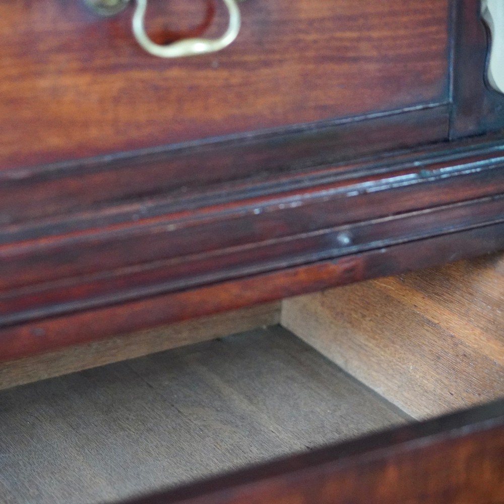 A George III mahogany chest on chest featuring two short over six long graduated drawers, a brushing slide, blind fretwork frieze, brass swan-neck handles, and bracket feet. View XI