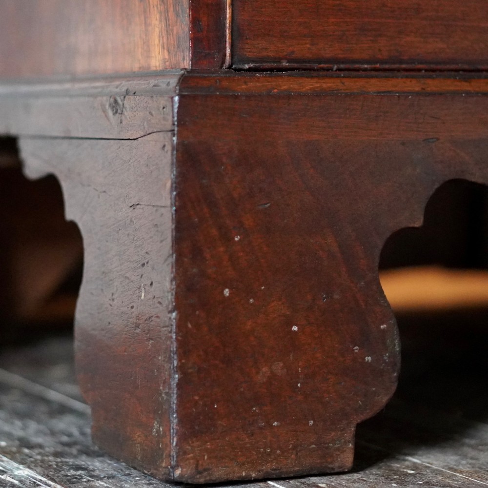 A George III mahogany chest on chest featuring two short over six long graduated drawers, a brushing slide, blind fretwork frieze, brass swan-neck handles, and bracket feet. View XIII
