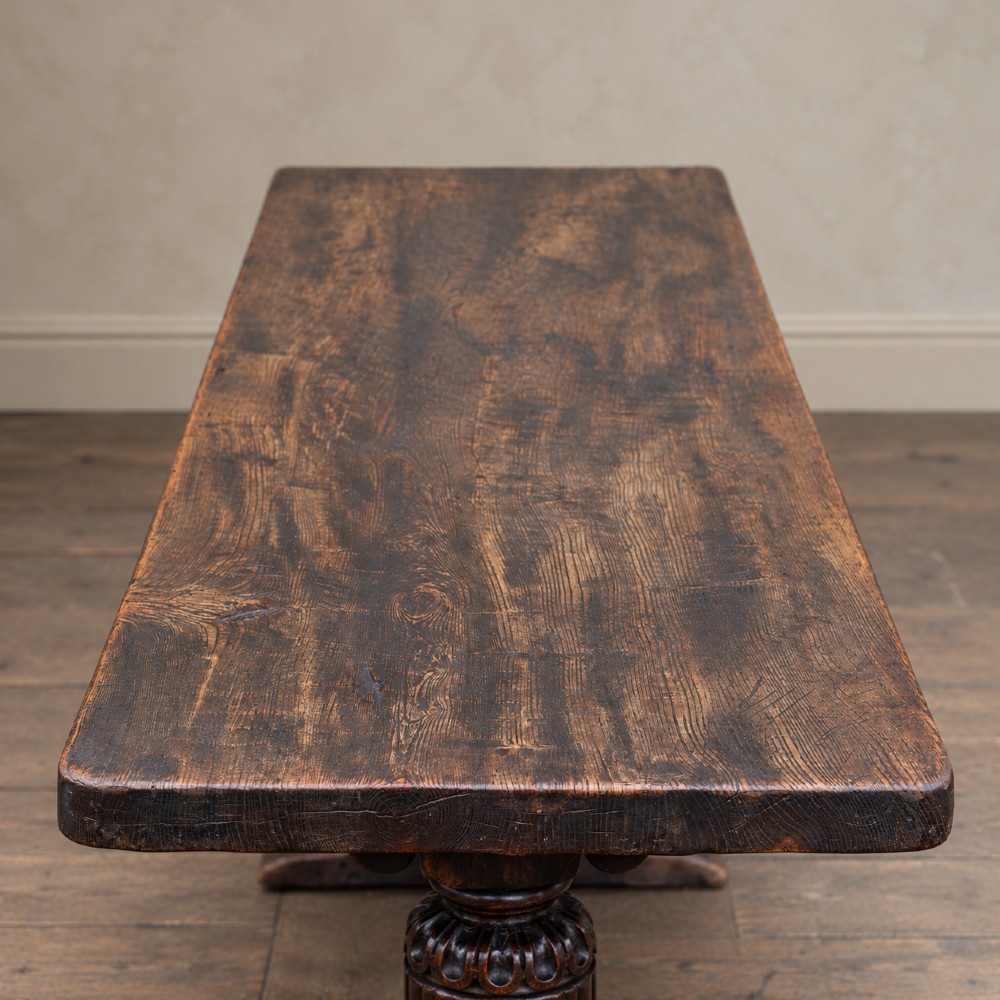 A 17th-century oak and elm refectory dining table featuring a solid single-plank top over thick carved bulbous pedestal supports and a low central stretcher rail. View II