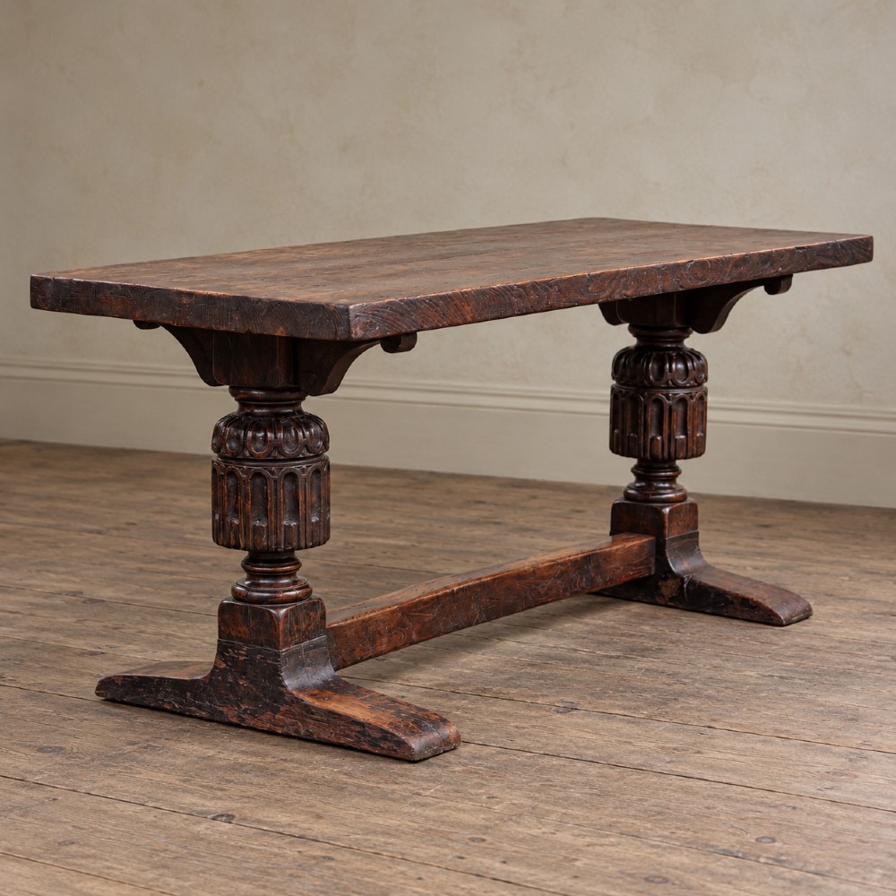 A 17th-century oak and elm refectory dining table featuring a solid single-plank top over thick carved bulbous pedestal supports and a low central stretcher rail. View IV