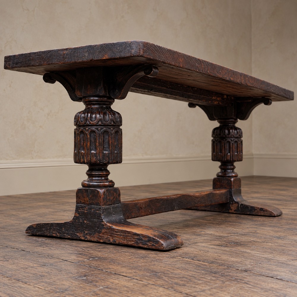 A 17th-century oak and elm refectory dining table featuring a solid single-plank top over thick carved bulbous pedestal supports and a low central stretcher rail. View VI