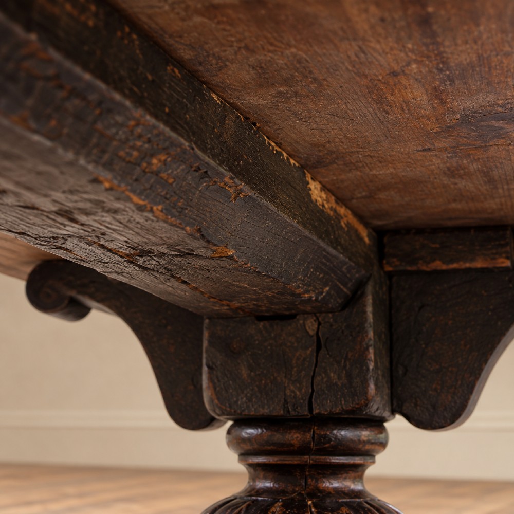 A 17th-century oak and elm refectory dining table featuring a solid single-plank top over thick carved bulbous pedestal supports and a low central stretcher rail. View VII