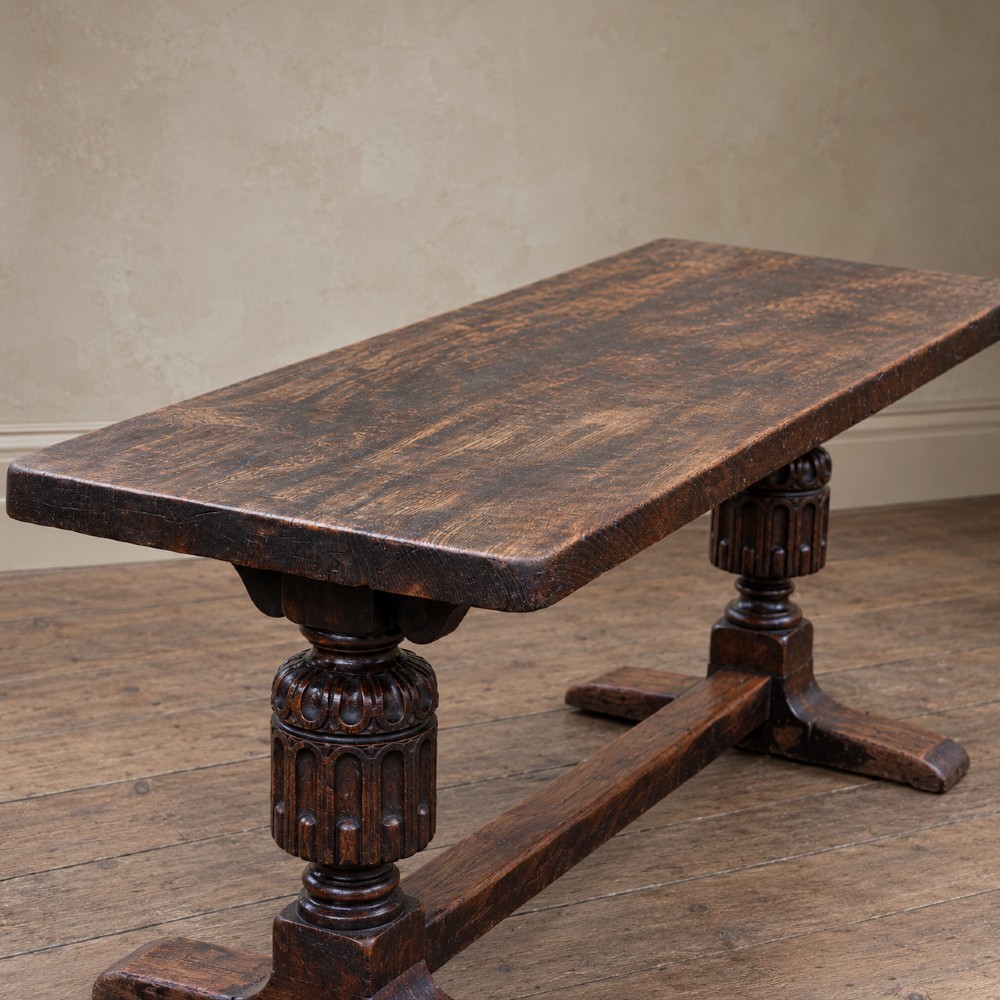 A 17th-century oak and elm refectory dining table featuring a solid single-plank top over thick carved bulbous pedestal supports and a low central stretcher rail. View X