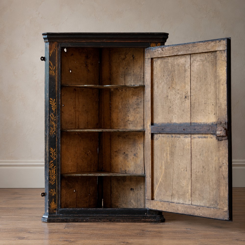 An 18th-century black japanned single-door wall corner cupboard featuring hand-painted gold Chinoiserie figures, architectural motifs, and brass butterfly hinges. View II