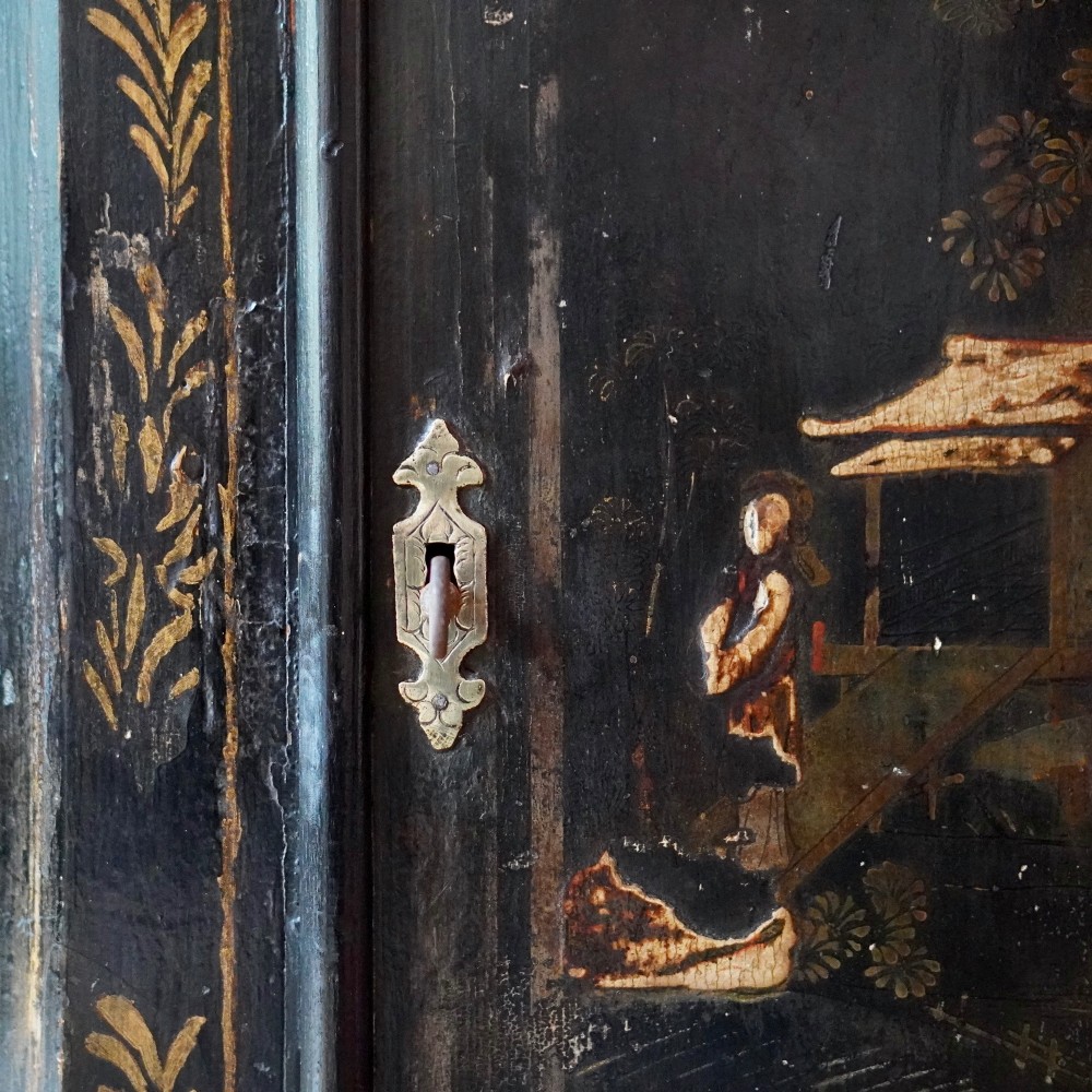 An 18th-century black japanned single-door wall corner cupboard featuring hand-painted gold Chinoiserie figures, architectural motifs, and brass butterfly hinges. View IV