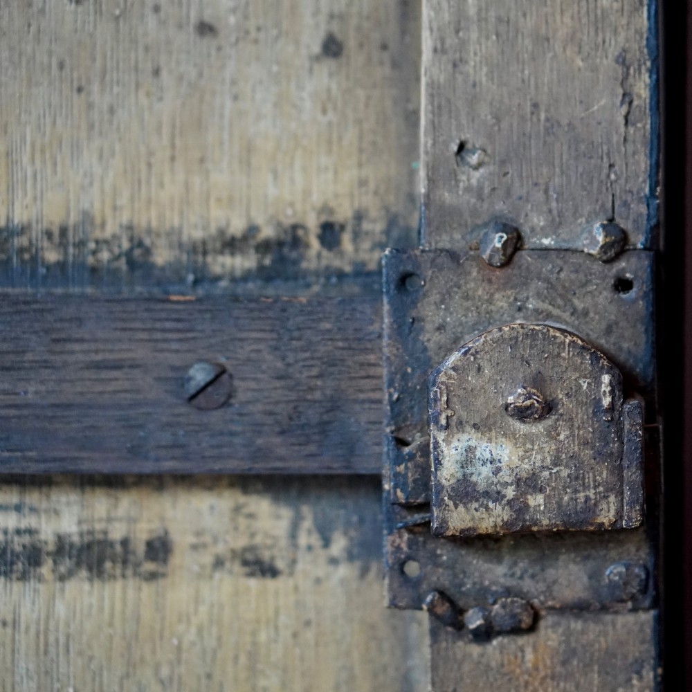 An 18th-century black japanned single-door wall corner cupboard featuring hand-painted gold Chinoiserie figures, architectural motifs, and brass butterfly hinges. View XI