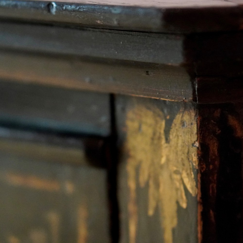 An 18th-century black japanned single-door wall corner cupboard featuring hand-painted gold Chinoiserie figures, architectural motifs, and brass butterfly hinges. View XV