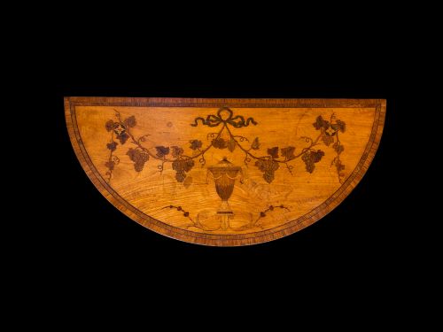 fig 2. A pair of George III period semi-circular satinwood side tables featuring inlaid marquetry tops and square tapered legs.