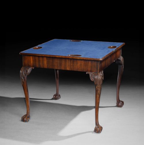fig 1. A George II mahogany fold-over card table featuring carved acanthus knees, cabriole legs, and claw and ball feet.