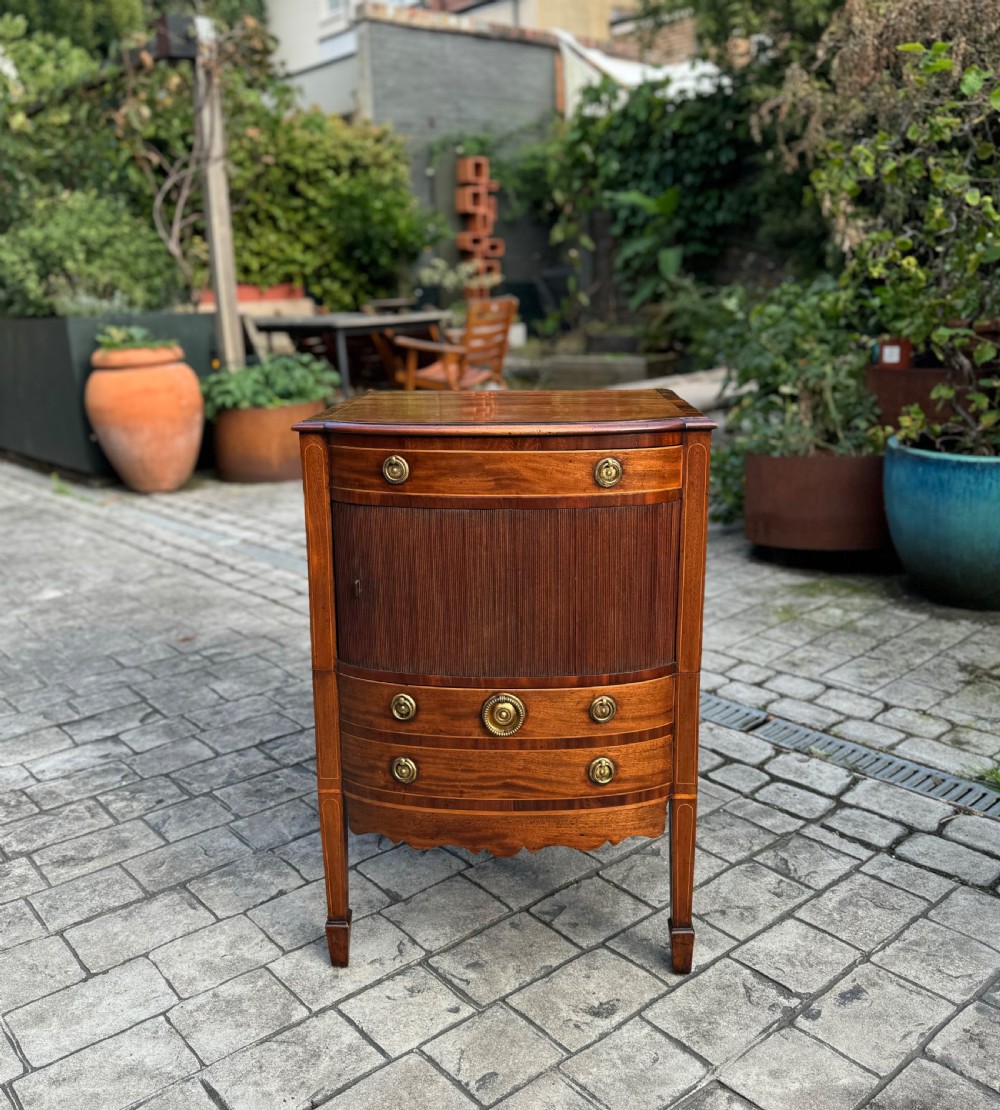 A pair of George III mahogany bedside cabinets featuring tambour slatted doors, brass ring handles, satinwood inlay, and tapered legs. View IV