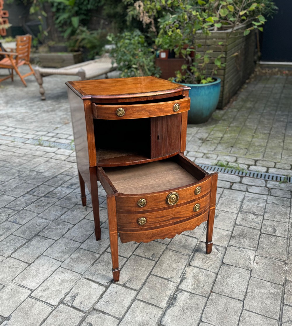 A pair of George III mahogany bedside cabinets featuring tambour slatted doors, brass ring handles, satinwood inlay, and tapered legs. View V