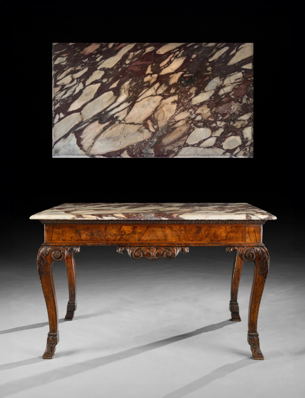 An 18th-century George II carved walnut side table featuring a variegated marble top, carved frieze, and cabriole legs with leaf details. View II